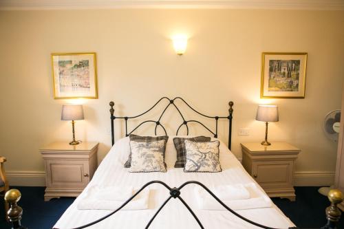 a bedroom with a large bed with two lamps at Milebrook House in Knighton
