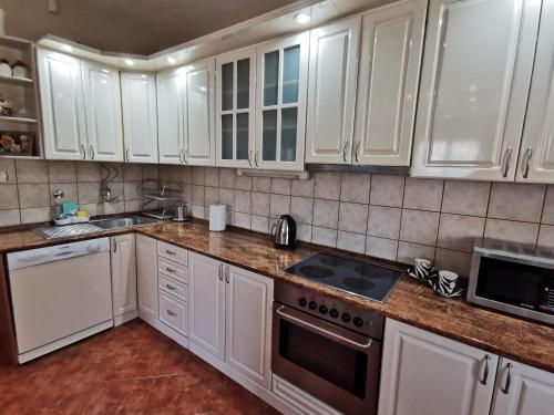 a kitchen with white cabinets and a stove top oven at Apartments "Villa Miona" in Belgrade