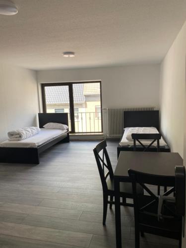 a room with two beds and a table and chairs at Ferienzimmer Nr.20 in Bad Neuenahr-Ahrweiler