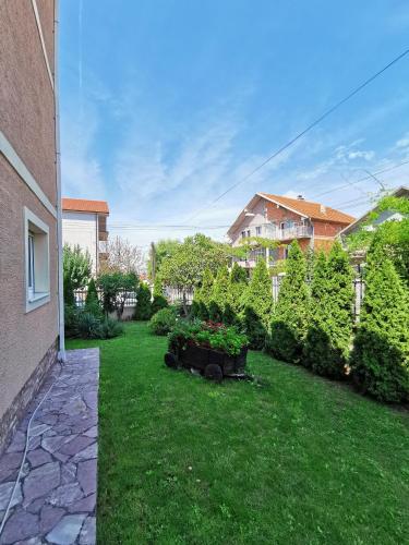 a yard with a garden with plants and a house at Apartments "Villa Miona" in Belgrade