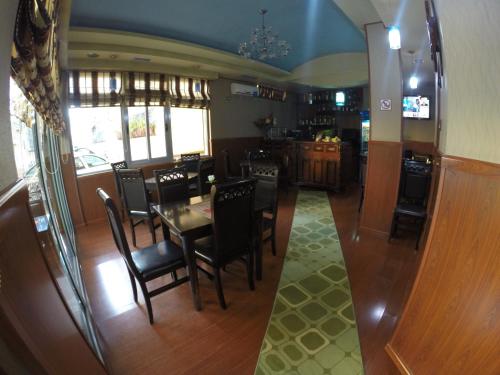 Hotel 3A في تيرانا: غرفة طعام ومطبخ مع طاولة وكراسي
