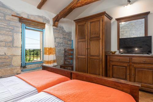 Sveti Lovreč PazenatičkiにあるVilla Jankoのベッドルーム1室(ベッド2台、テレビ、キャビネット付)