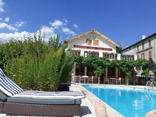 a person laying on a chair next to a swimming pool at Logis Hôtel Restaurant Le 1050 in Saint-Agrève