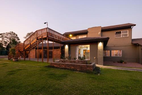 a house with a staircase on the side of it at Fever Tree Guesthouse in Hillcrest