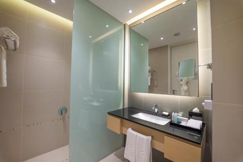 a bathroom with a sink and a mirror at Dana Rayhaan by Rotana in Dammam