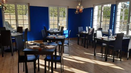 a dining room with tables and chairs and blue walls at Logis Hôtel Restaurant Le 1050 in Saint-Agrève