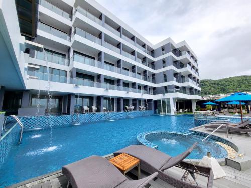 a swimming pool in front of a building at The Yama Hotel Phuket - SHA Extra Plus in Kata Beach
