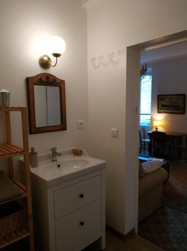 une salle de bain avec un lavabo, un miroir et un canapé dans l'établissement Le Voltaire, à Souppes-sur-Loing