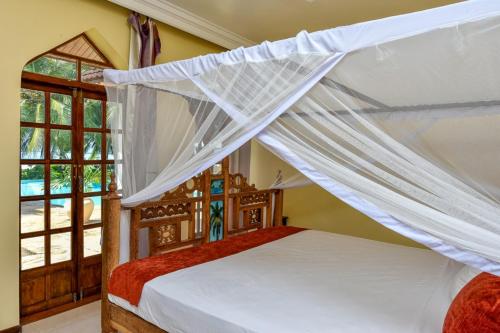 เตียงในห้องที่ Garden Beach Villa Zanzibar