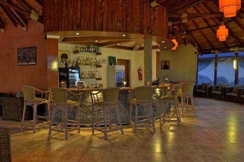 a restaurant with a bar with chairs and a counter at Sentrim Elementaita Lodge in Elmenteita