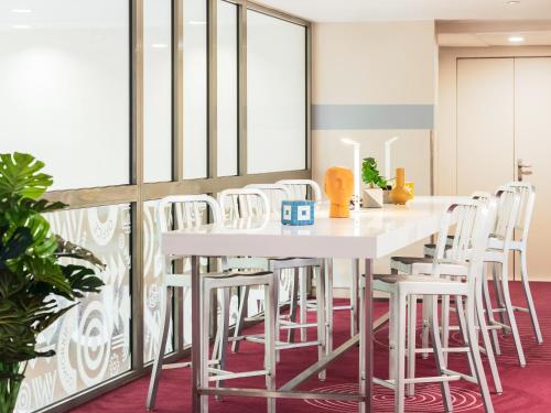 a dining room with a white table and white chairs at Mercure Paris Centre Tour Eiffel in Paris