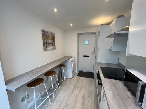 a kitchen with a counter and stools in it at Luxury 2 bedroom apartment near the O2 and Canary Wharf in Eltham