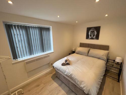 a bedroom with a bed with a skull picture on the wall at Luxury 2 bedroom apartment near the O2 and Canary Wharf in Eltham