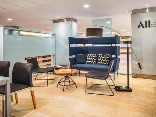 a waiting room with chairs and a blue chair at Mercure Paris Centre Tour Eiffel in Paris