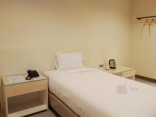 a bedroom with a bed and a phone on a table at Kaizen Suites in Manila