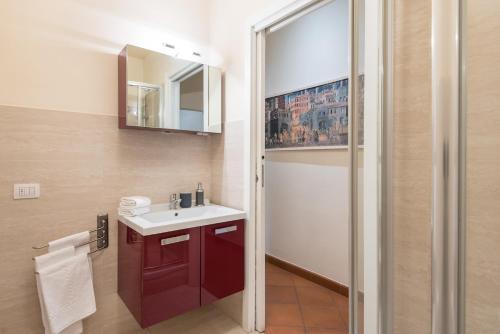 ein Badezimmer mit einem roten Waschbecken und einem Spiegel in der Unterkunft Design Apartments Florence Combo in Florenz