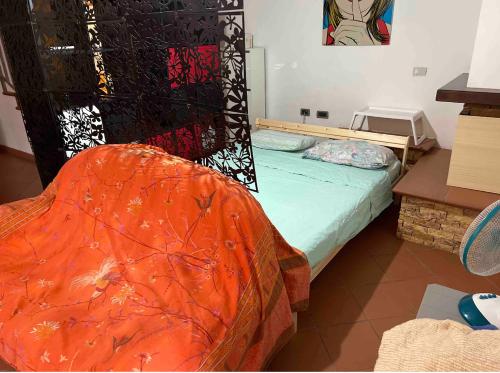 a bedroom with a bed with an orange blanket on it at Taverna indipendente zona Ospedale Pescara in Pescara