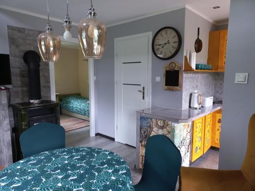 a kitchen with a table and a clock on the wall at Dom Zegarmistrza in Mirosławiec