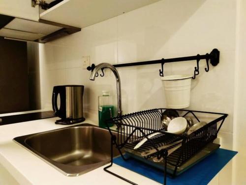 H2O Retreat Studio Home 5min to LRT by Premium Stay في بيتالينغ جايا: حوض المطبخ مع رف لتجفيف الأطباق بجواره