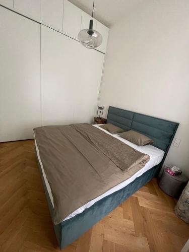 a bedroom with a large bed with a blue headboard at Luxury apartment in the centre in Prague