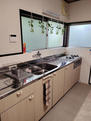 eine Küche mit einer Spüle und einer Arbeitsplatte in der Unterkunft SIBARIAN Guest House in Kaga