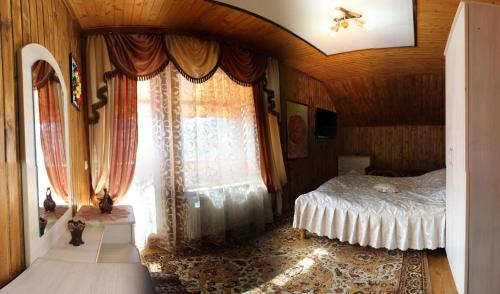 a bedroom with a bed and a large window at Kovcheg Holiday Home in Mykulychyn