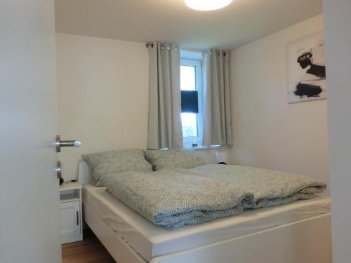 una cama en una habitación con ventana en Ferienwohnung am Argental, en Wangen im Allgäu