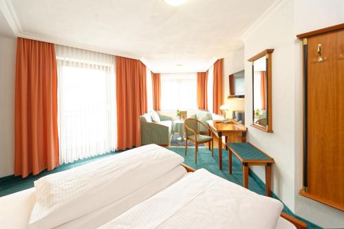 a hotel room with a bed and a table at Hotel Edelweiss in Maria Alm am Steinernen Meer