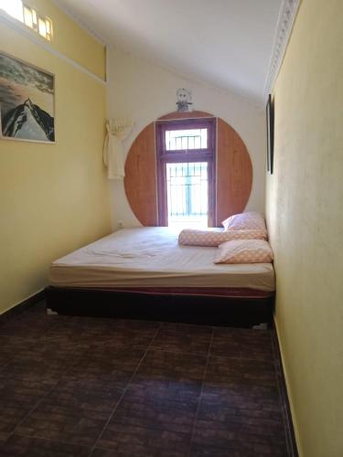 a small bedroom with a bed and a window at Villa kota bunga cipanas 3 kamar baru in Cikundul