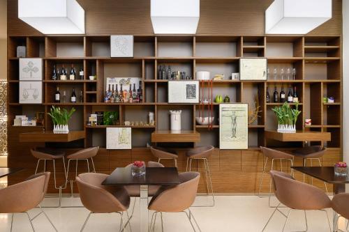 um restaurante com mesas e cadeiras e prateleiras com garrafas de vinho em Eos Hotel em Lecce