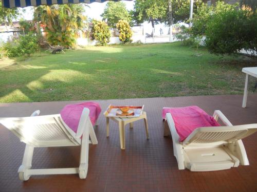 a patio with two chairs and a table with at villa marie eugenie in Les Trois-Îlets