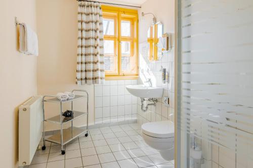 a white bathroom with a sink and a toilet at Watzdorfer Geleitschenke und Herberge in Weimar