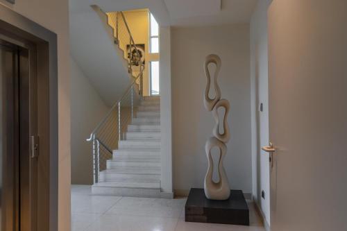 a hallway with a staircase with a vase on a table at Eos Hotel in Lecce