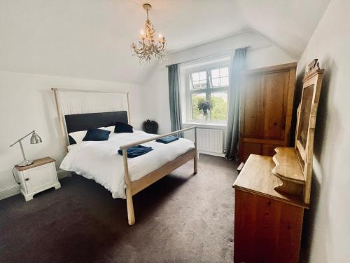 a bedroom with a bed and a window and a chandelier at Lauderdale lodge barnstaple in Barnstaple