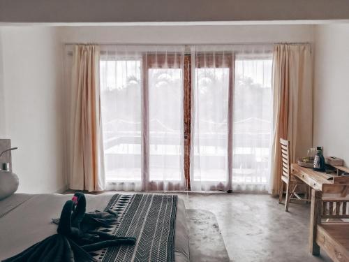 1 dormitorio con cama y ventana grande en Sanctum Hotel and Dive- Nusa Penida, en Nusa Penida