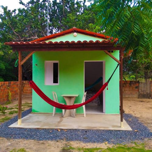 a small green house with a red rope around it at Mila chalé in Cruz