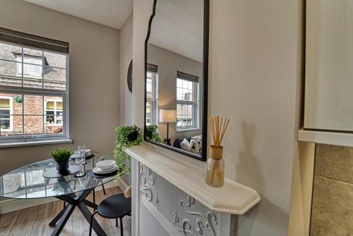 a dining room with a table and a mirror at Guest Homes - Taylor Apartment in Worcester