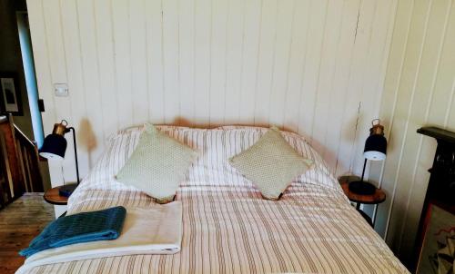 uma cama com duas almofadas e um livro sobre ela em Shoe Trader's Terrace em Rathmullan