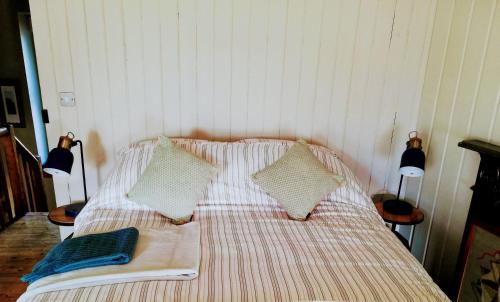 a bed with two pillows and a book on it at Shoe Trader's Terrace in Rathmullan