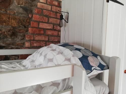 a white bunk bed in a room with a brick wall at Shoe Trader's Terrace in Rathmullan