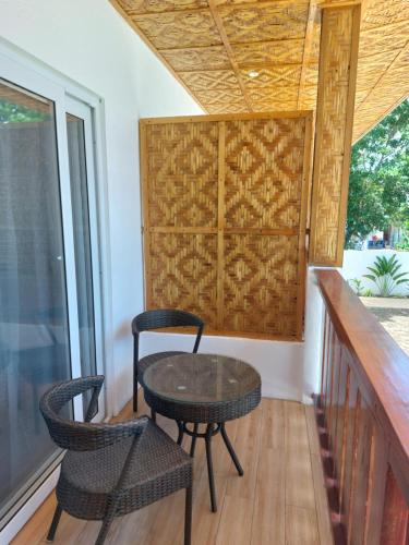a balcony with a table and chairs on a porch at Yellow Mango Resort Bohol in Panglao Island