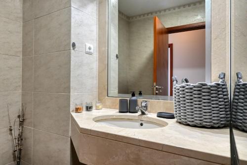 een badkamer met een wastafel en een spiegel bij Forum Escape, a Home in Madeira in Funchal