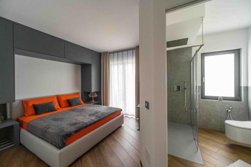 a bedroom with an orange bed and a bath tub at Dolomiti Nice1 in Belluno