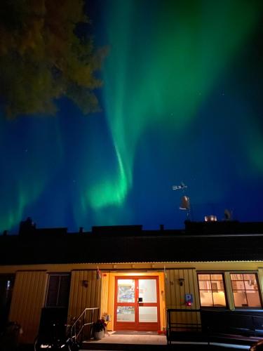 a building with the aurora in the sky at Lumi Guest House in Arvidsjaur