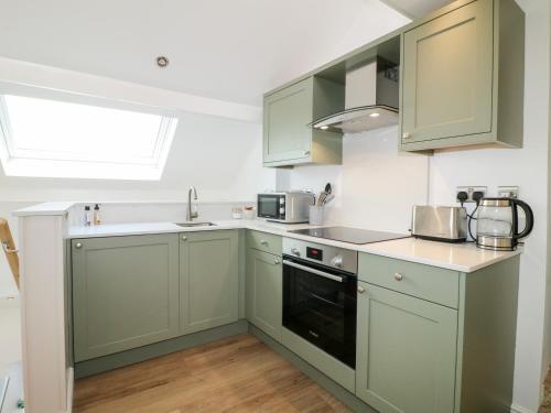 a kitchen with green cabinets and a sink at The Hayloft in Matlock
