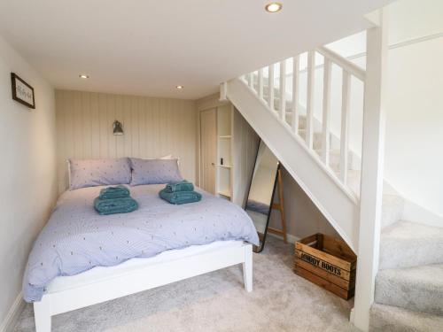 a bedroom with a bed and a staircase at The Hayloft in Matlock
