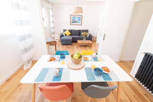 - une salle à manger et un salon avec une table et des chaises blanches dans l'établissement Appartement Cosy et Lumineux - Tout équipé - Hypercentre Lorient par Groom, à Lorient