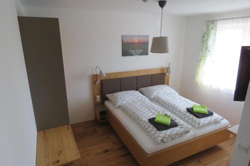 1 dormitorio con 1 cama con 2 almohadas verdes en Gasthof Schmidt, 