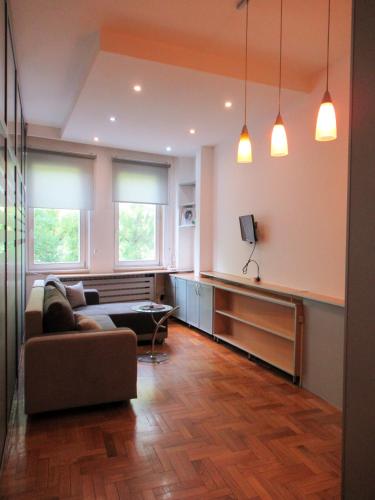 ein Wohnzimmer mit einer Couch und zwei Fenstern in der Unterkunft Apartment Grmech in Novi Beograd