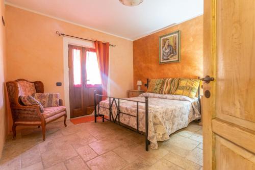 sypialnia z łóżkiem, krzesłem i oknem w obiekcie Casa Girasole w mieście Roccastrada